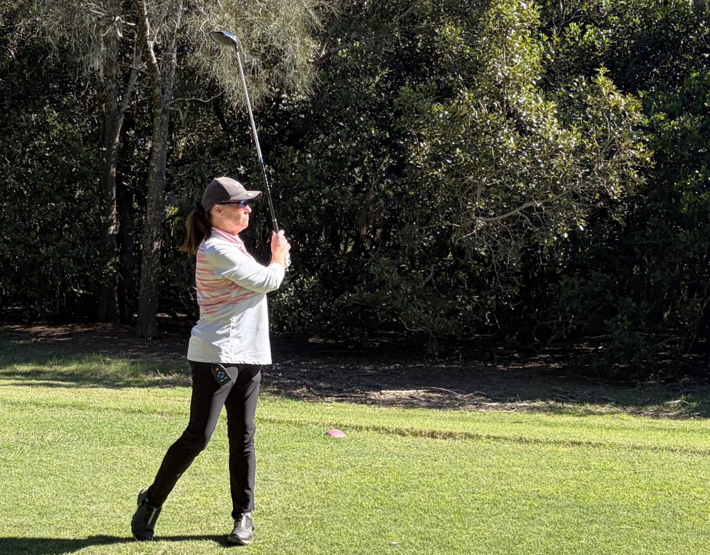 Deb Booth watches her tee shot on 14.
